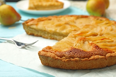 Photo of Cut delicious sweet pear tart on table, closeup