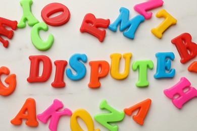 Word Dispute made of colorful letters on white marble table, flat lay