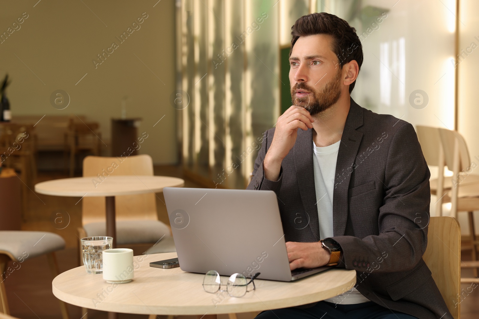 Photo of Man with laptop at table in cafe