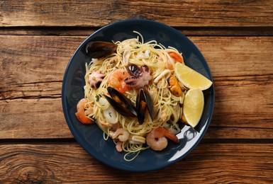 Delicious pasta with sea food on wooden table, top view