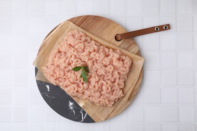 Photo of Fresh raw minced meat on white tiled table, top view