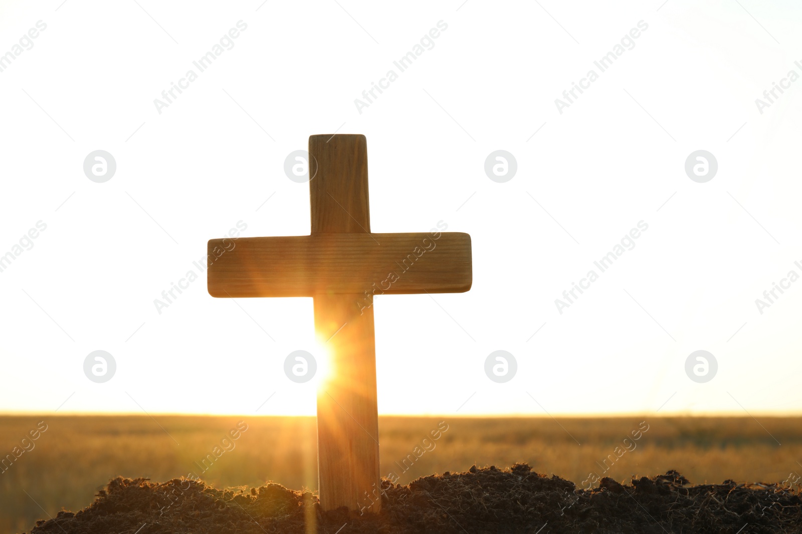 Photo of Wooden Christian cross outdoors at sunrise, space for text. Religion concept