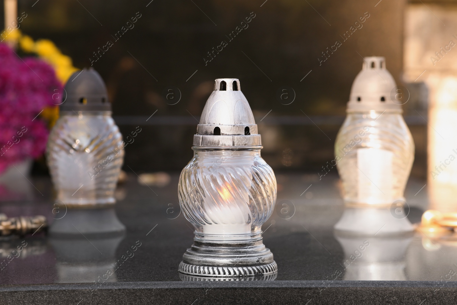 Photo of Grave lanterns on granite surface in cemetery