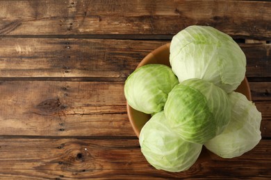 Photo of Ripe white cabbage on wooden table, top view. Space for text