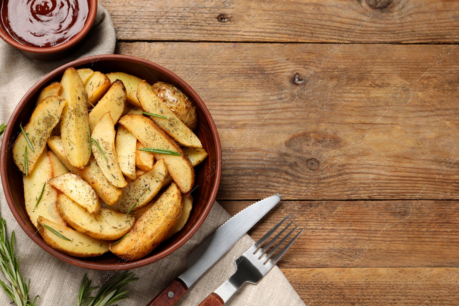 Photo of Delicious baked potatoes with spices served on wooden table, flat lay. Space for text