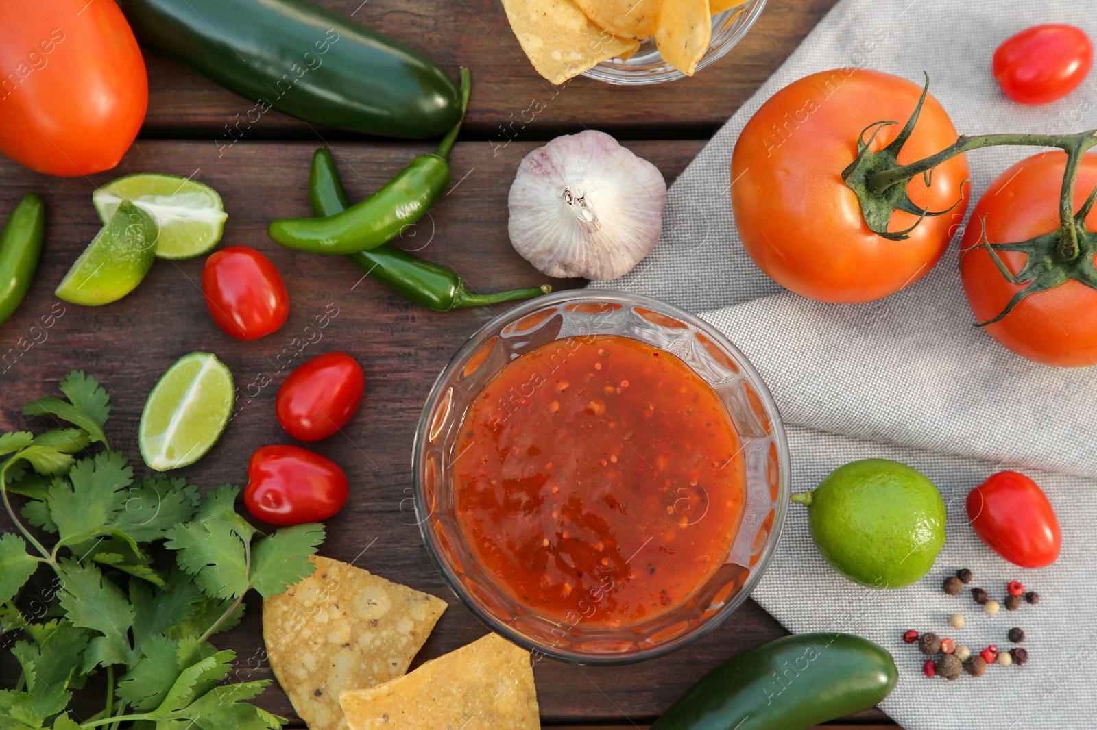 Photo of Flat lay composition of tasty salsa sauce and different ingredients on wooden table