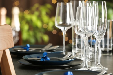 Table setting with empty glasses, plates and cutlery indoors