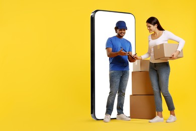 Courier delivering parcels to woman near huge smartphone on golden background