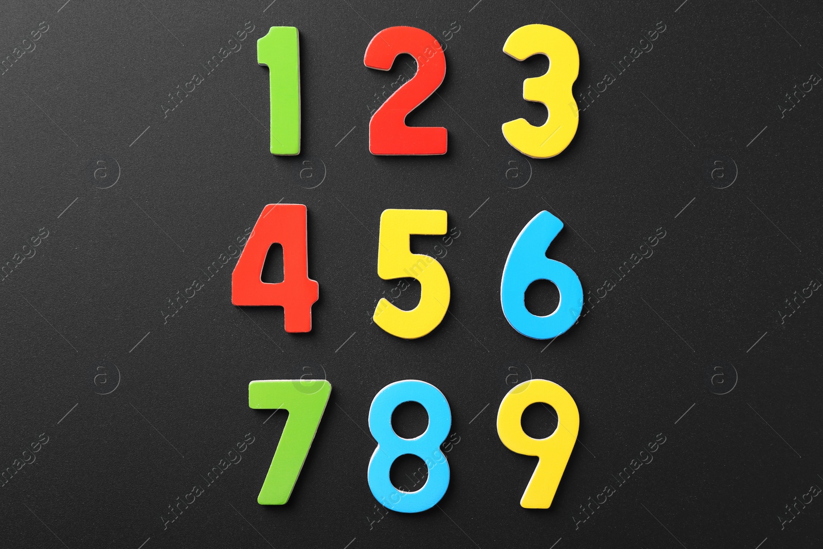 Photo of Colorful numbers on black background, flat lay