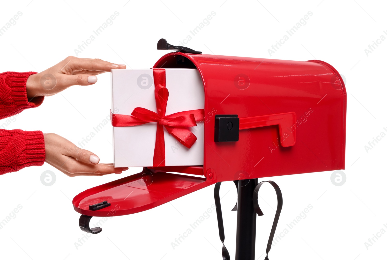 Photo of Woman putting Christmas gift into mailbox on white background, closeup. Sending present by mail