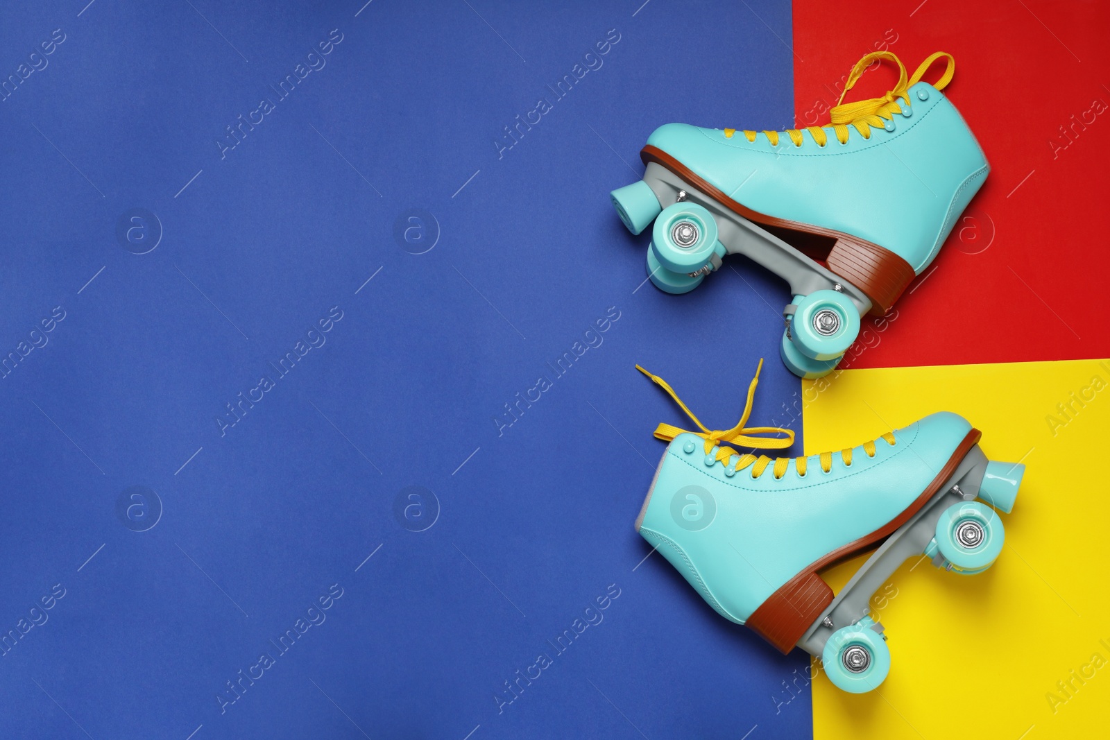 Photo of Pair of stylish quad roller skates on color background, top view with space for text