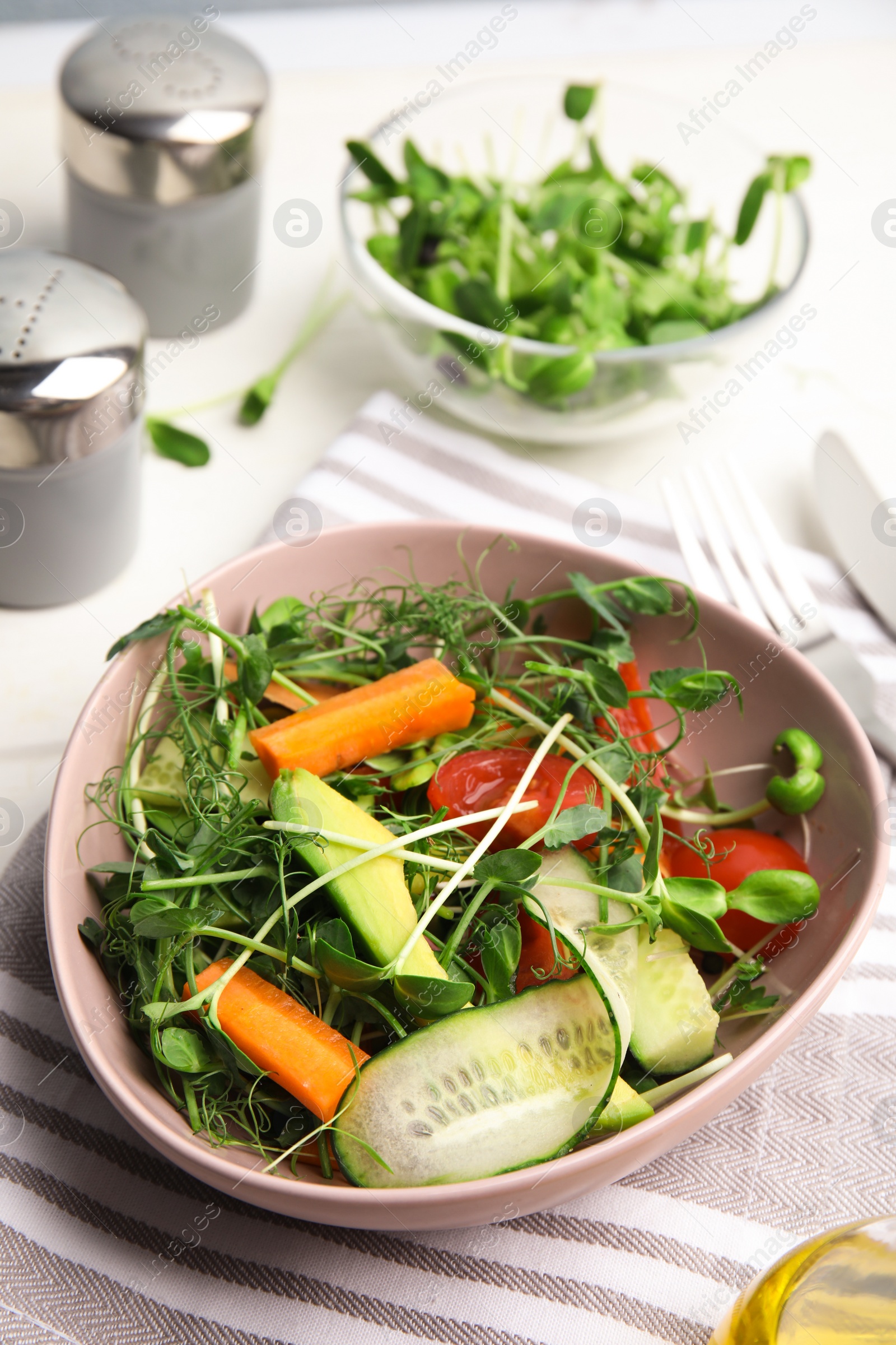 Photo of Salad with fresh organic microgreen in bowl on white table, above view