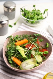 Photo of Salad with fresh organic microgreen in bowl on white table, above view