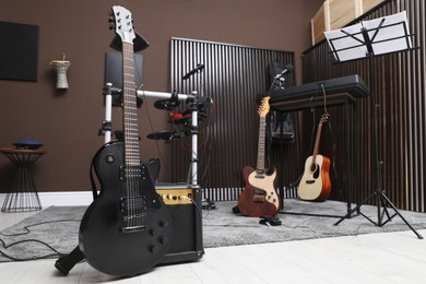 Photo of Electric guitar with amplifier at recording studio. Music band practice