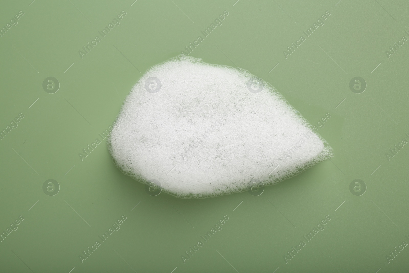 Photo of Sample of fluffy foam on green background, top view