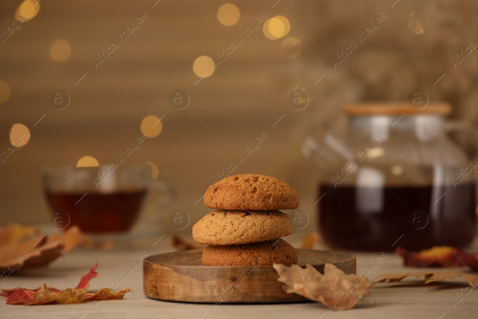 Photo of Delicious cookies and autumn leaves on wooden table