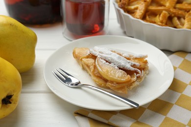 Piece of tasty homemade quince pie with powdered sugar served on white wooden table