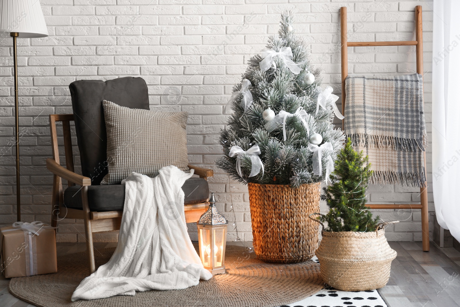 Photo of Stylish interior with beautiful Christmas tree near white brick wall