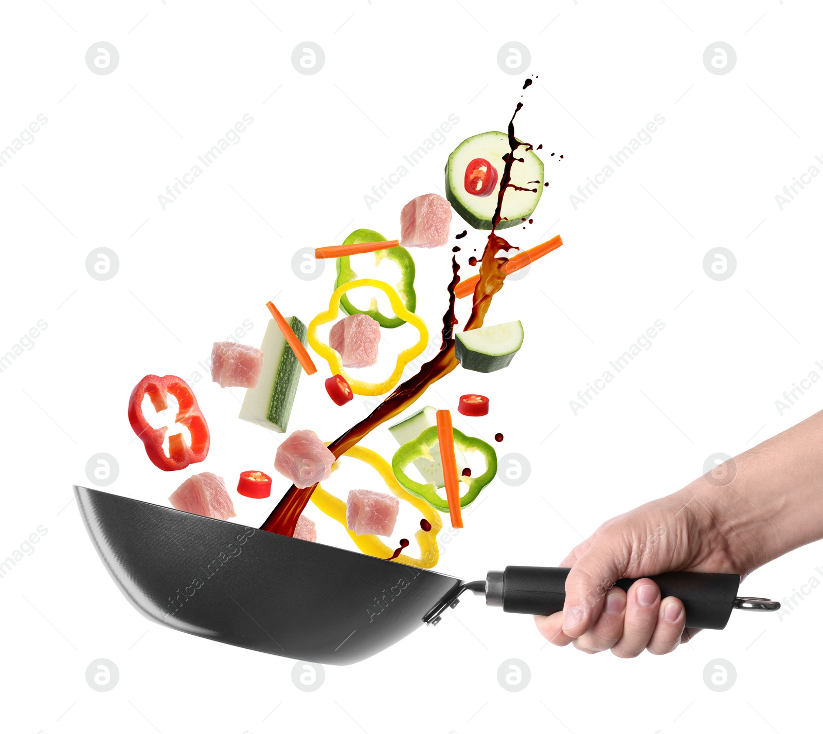 Image of Man tossing ingredients in wok on white background, closeup