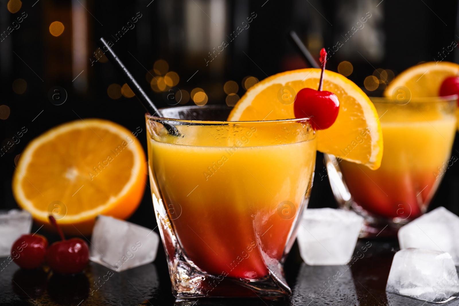 Photo of Fresh alcoholic Tequila Sunrise cocktail on black table