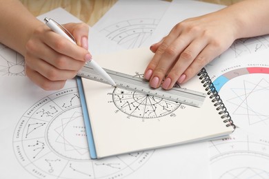 Photo of Astrologer using zodiac wheel for fate forecast at table, closeup. Fortune telling