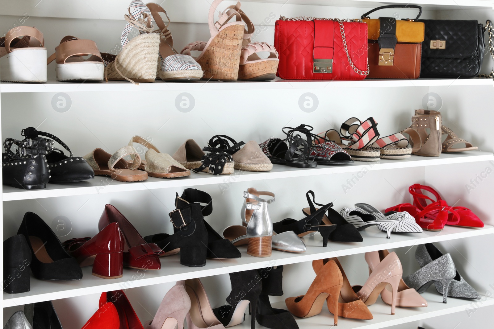 Photo of Shelving unit with different shoes. Element of dressing room interior