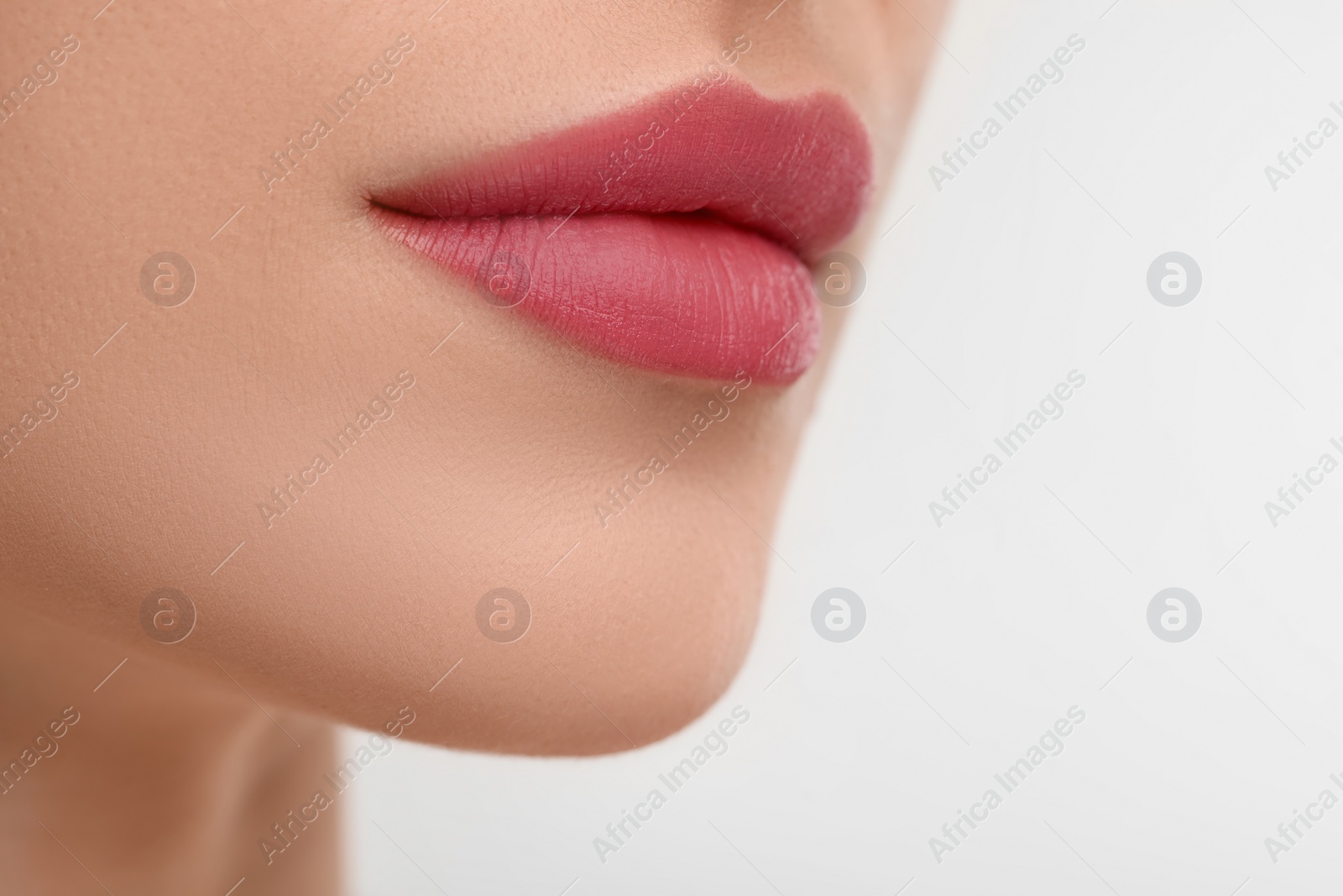 Photo of Young woman with beautiful full lips on white background, closeup