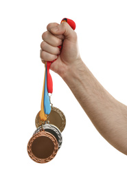 Man holding medals on white background, closeup. Space for design