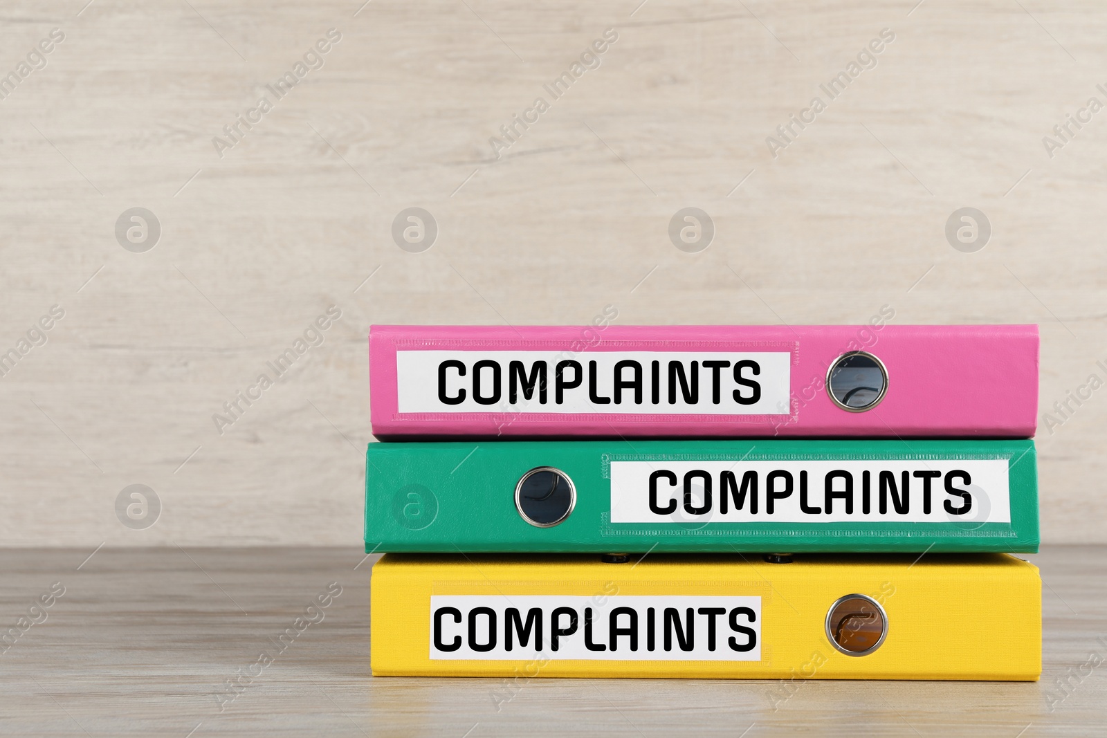 Image of Colorful folders with Complaints labels on table, space for text