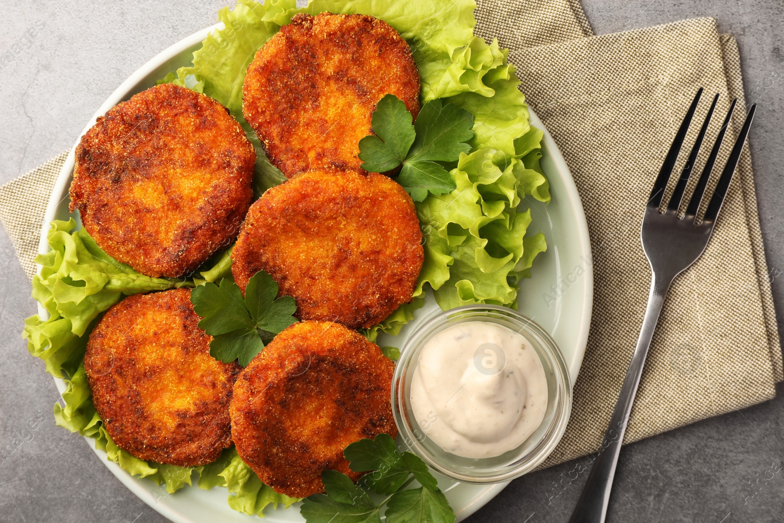 Photo of Tasty vegan cutlets served with sauce on light grey table, top view