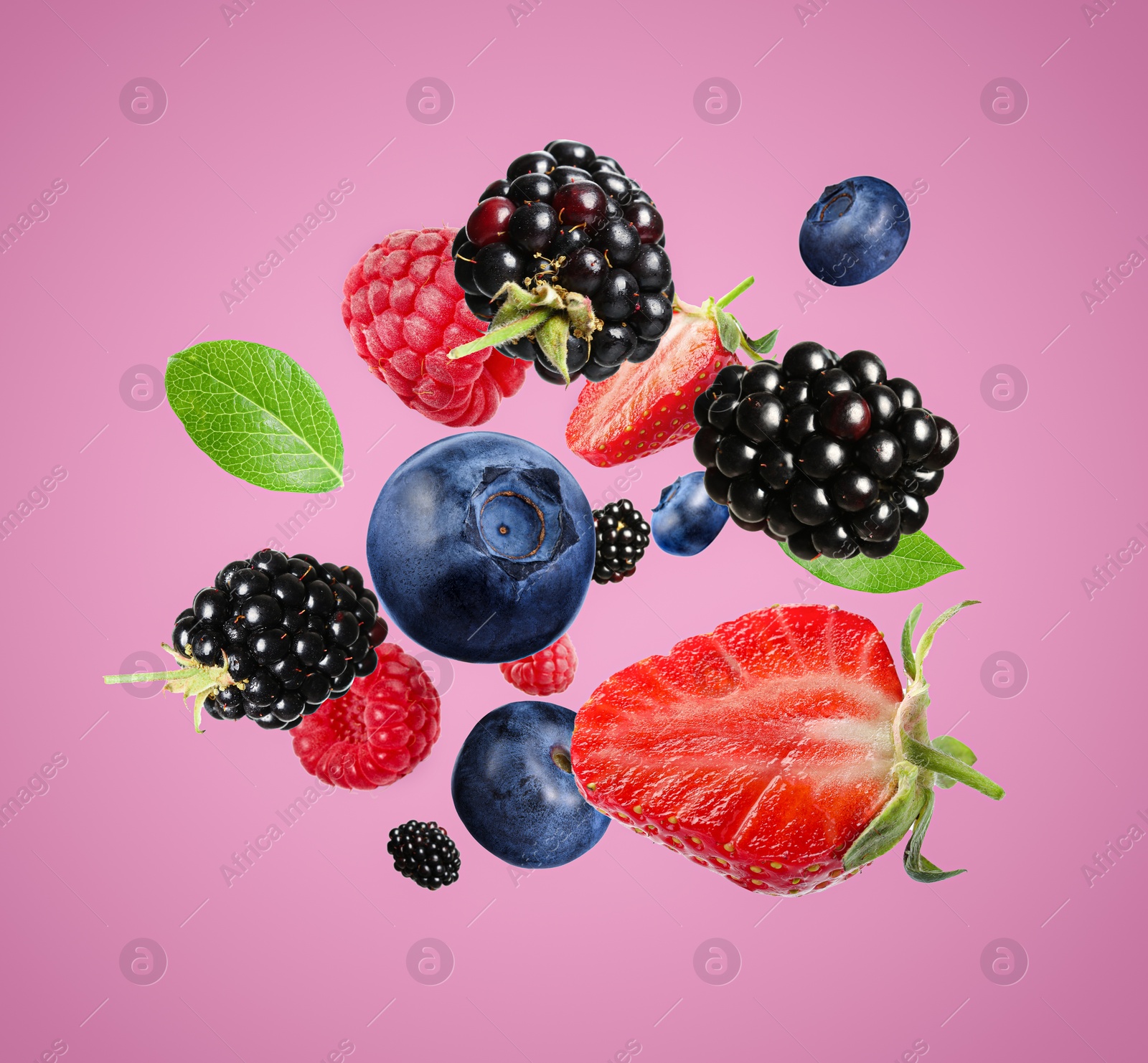 Image of Many different fresh berries falling on hot pink background