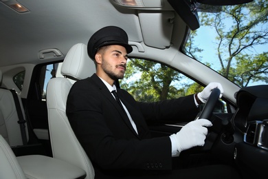 Young handsome driver in luxury car. Chauffeur service