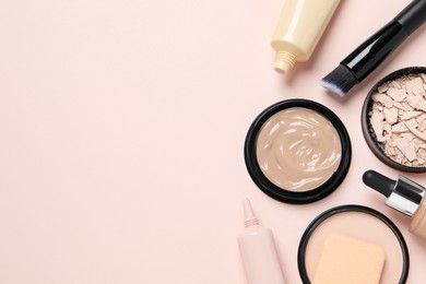 Liquid foundations, beauty accessories and face powders on beige background, flat lay. Space for text