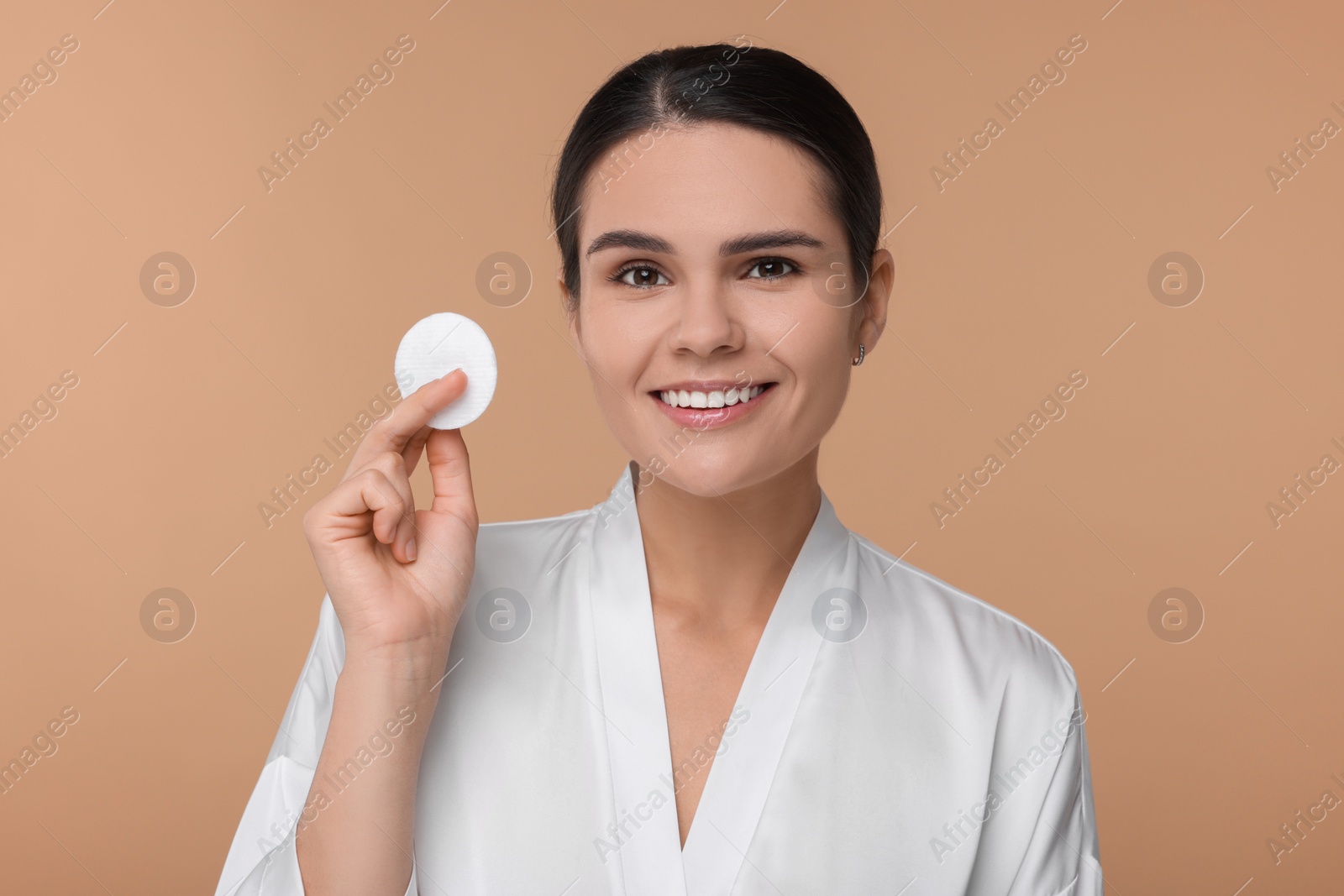 Photo of Young woman with cotton pad on beige background