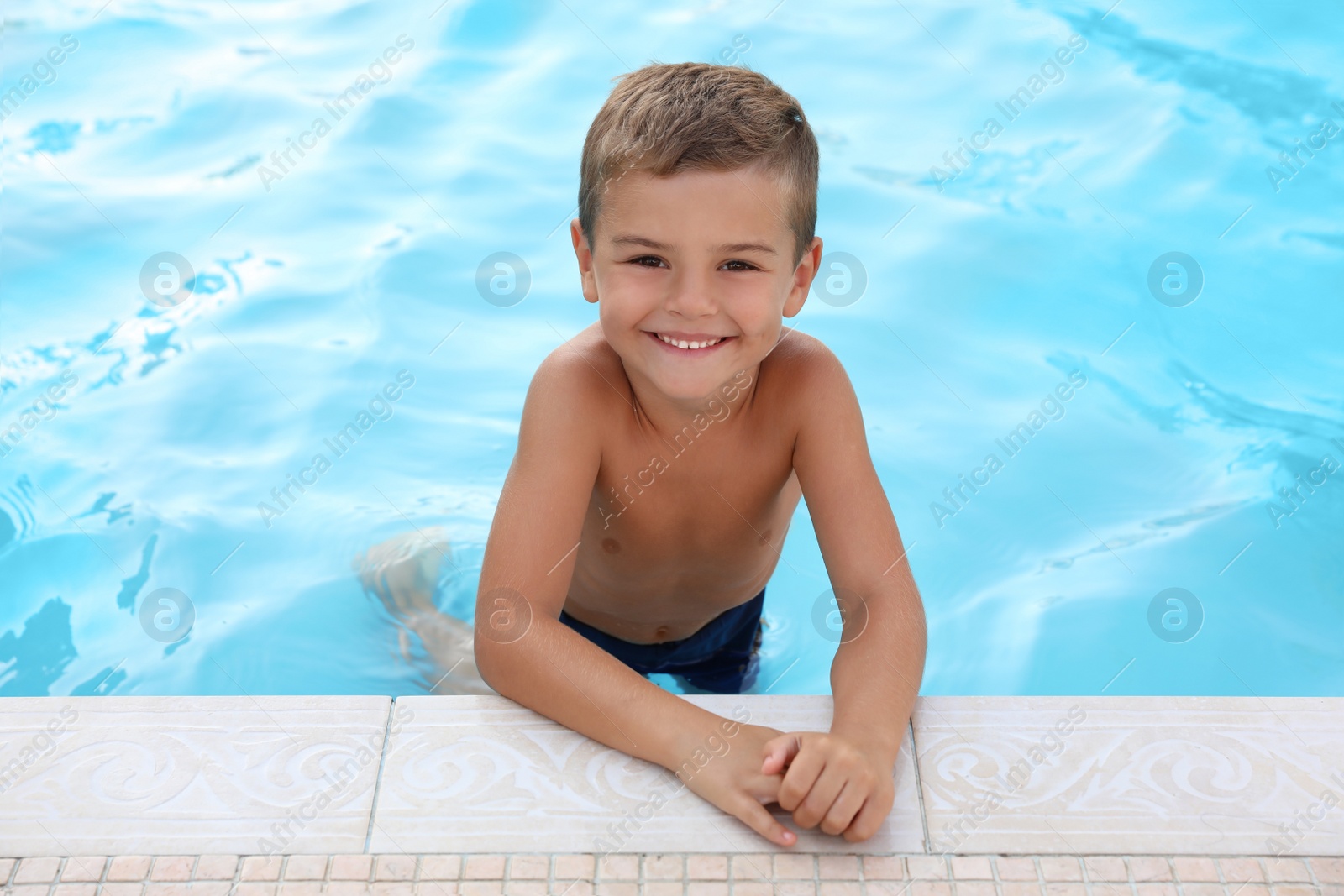 Photo of Cute little boy in outdoor swimming pool