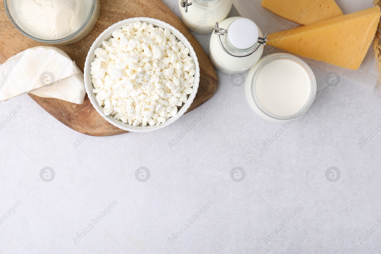 Photo of Different fresh dairy products on light table, flat lay. Space for text