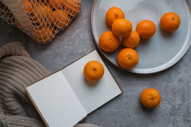 Photo of Flat lay composition with fresh ripe tangerines and book on light grey table
