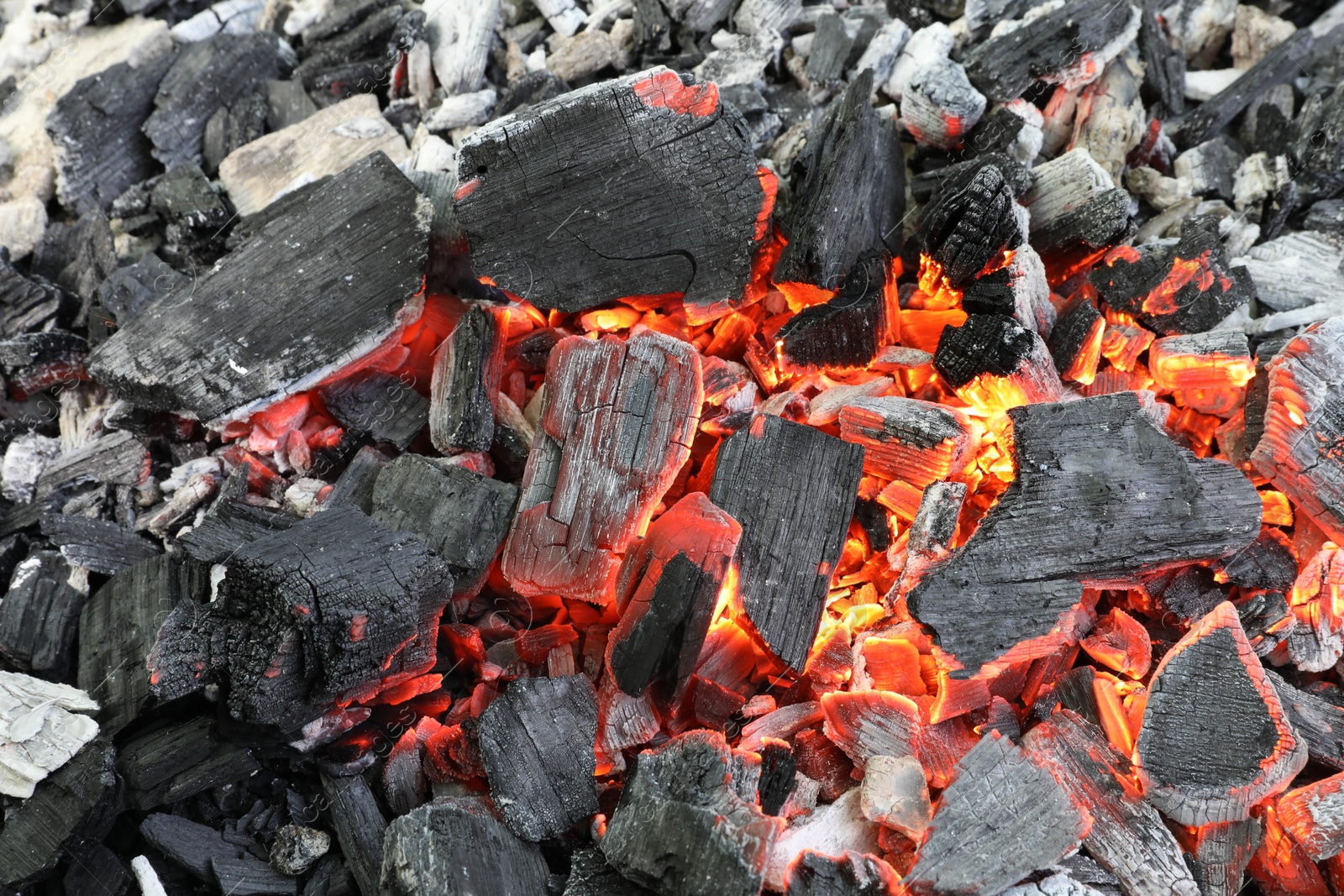 Photo of Many smoldering coals as background, closeup view