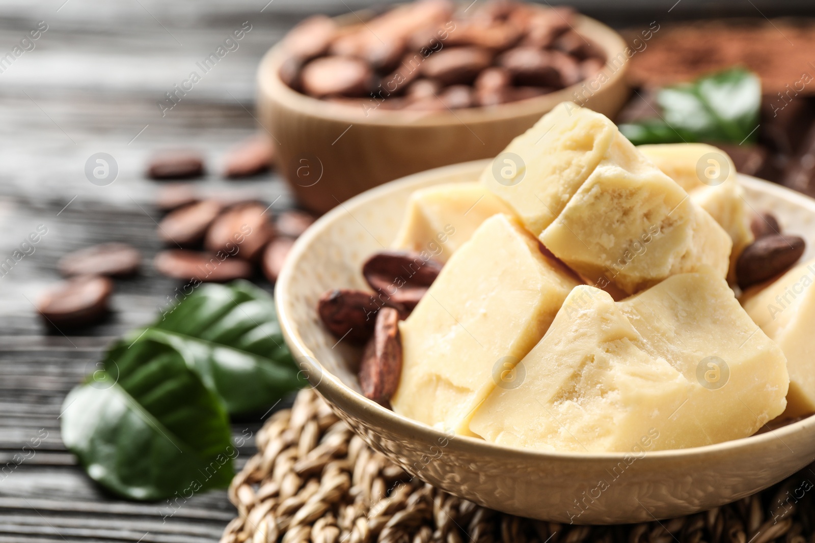 Photo of Organic cocoa butter on black wooden table, closeup