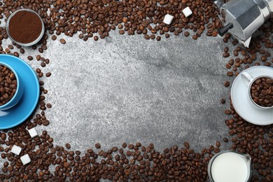 Flat lay composition with roasted coffee beans on grey table. Space for text