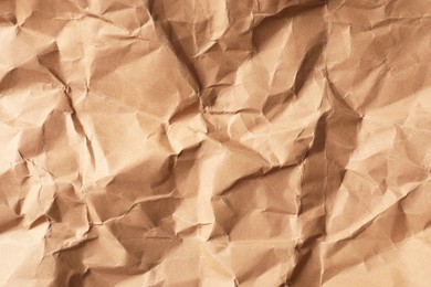 Photo of Crumpled kraft paper sheet as background, top view