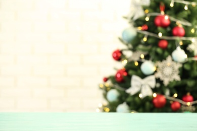 Photo of Empty wooden table against fir tree with Christmas lights, blurred view. Space for design