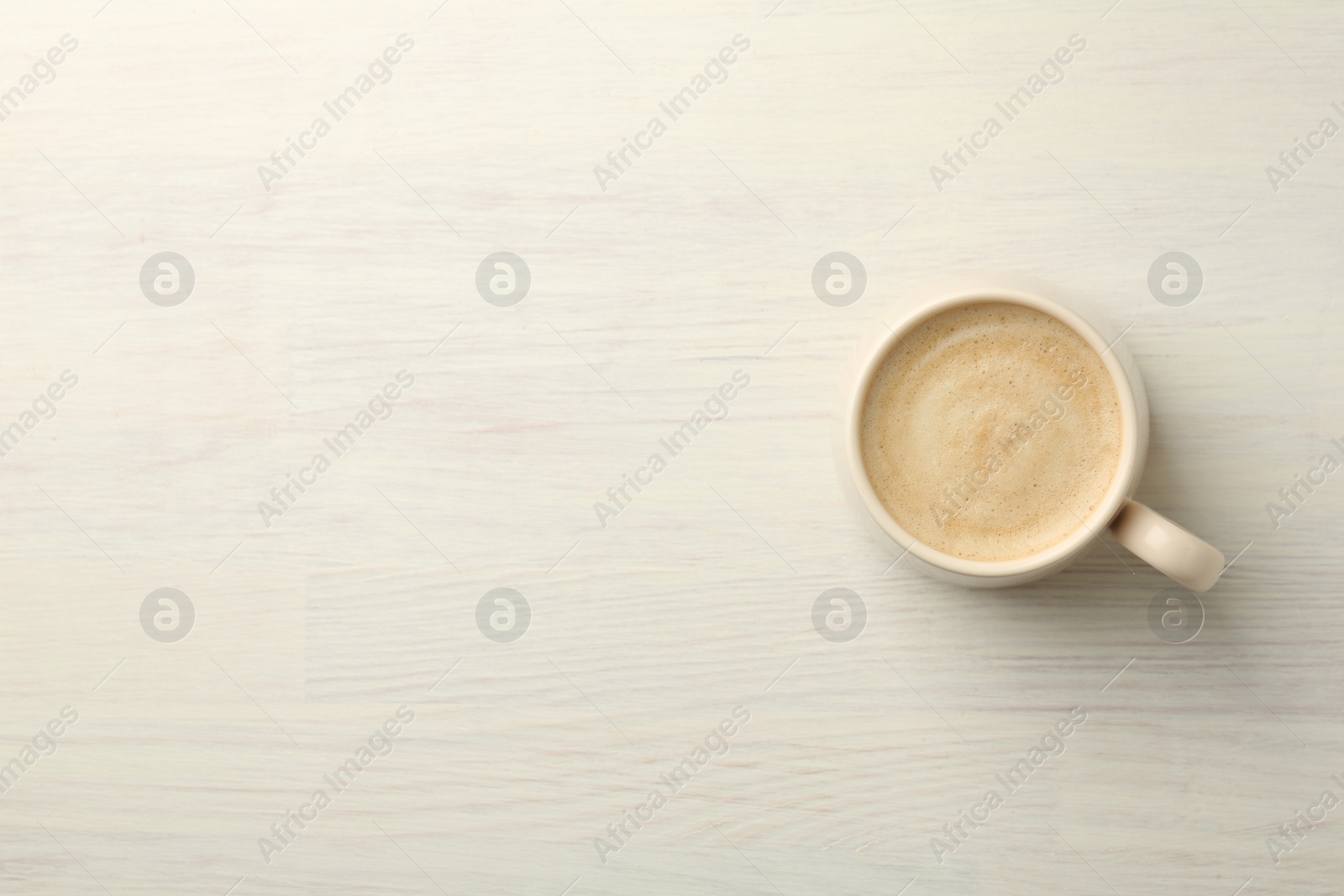 Photo of Cup of coffee on white wooden table, top view. Space for text