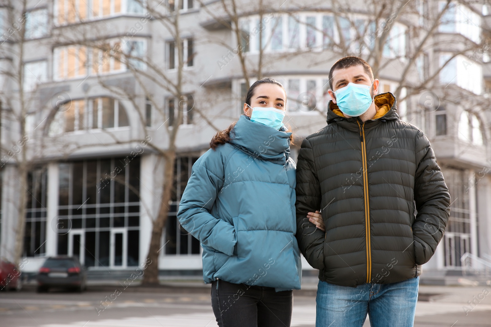 Photo of Couple wearing disposable masks outdoors. Dangerous virus