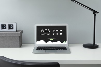 Image of Web hosting service. Comfortable workplace with modern laptop on white table