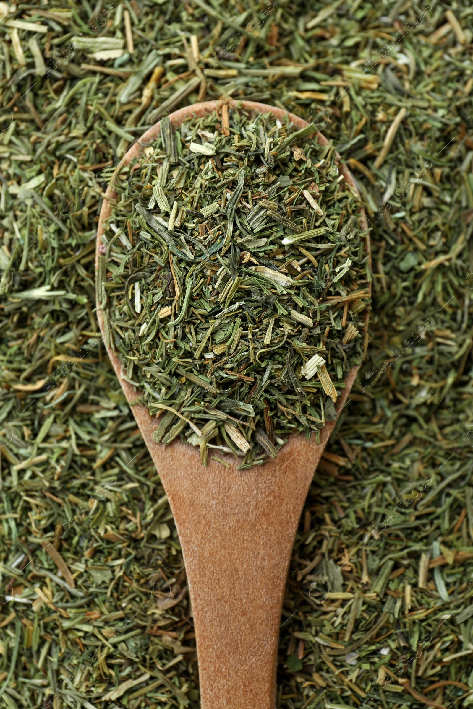 Photo of Pile of dried dill and wooden spoon, top view