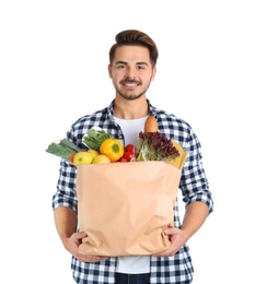 Young man holding paper bag with products on white background. Food delivery service