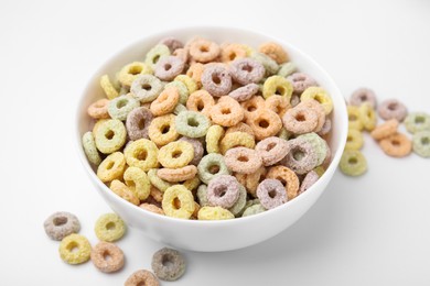 Photo of Tasty cereal rings in bowl on white table, closeup