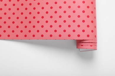 Roll of polka dot wrapping paper on white background, top view