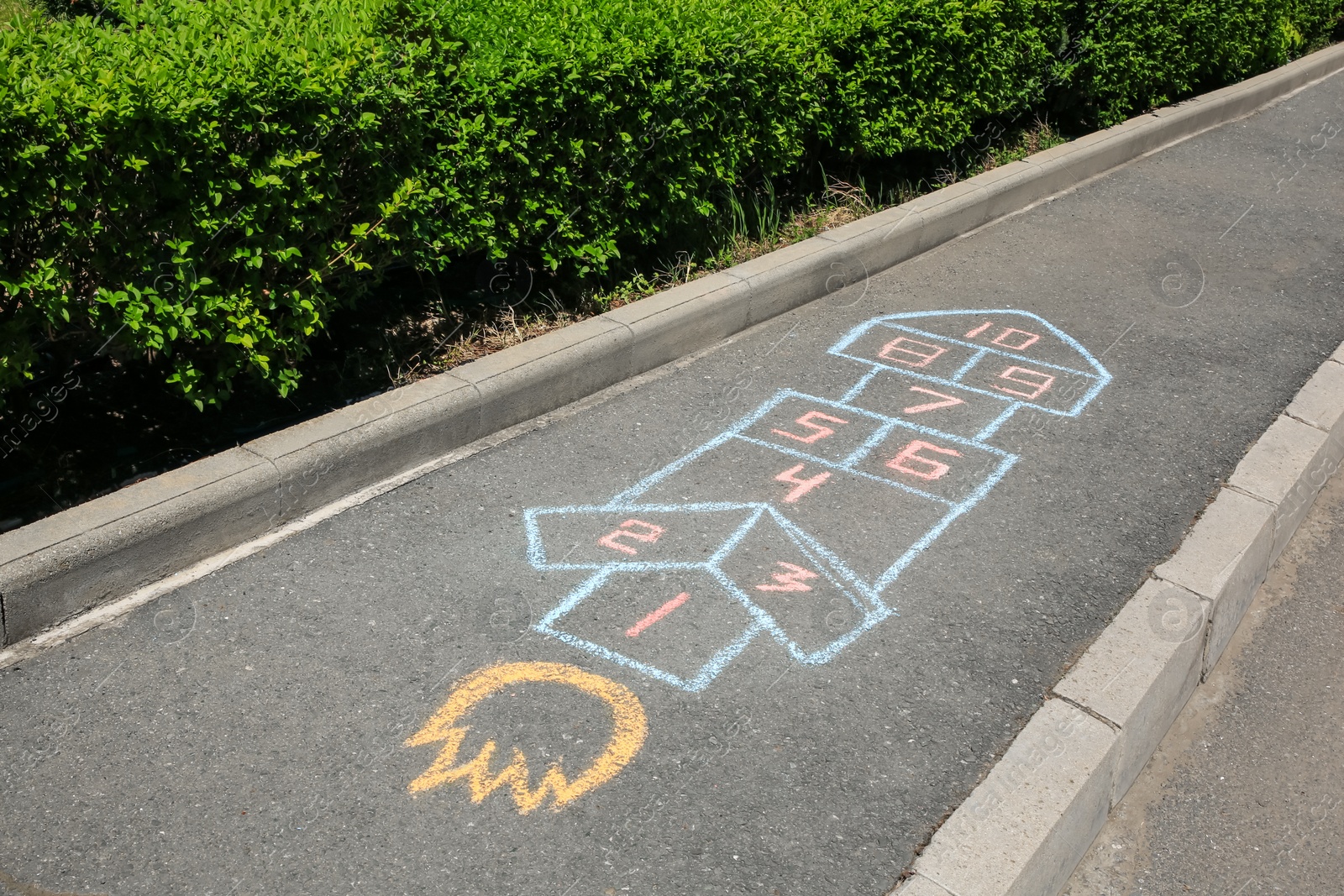 Photo of Hopscotch drawn with colorful chalk on asphalt outdoors